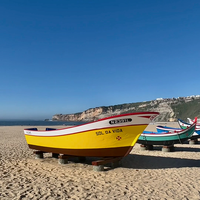 Traditional colorful fishing boats resting on a sandy beach