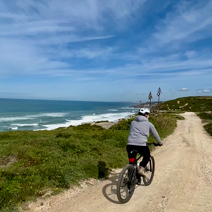 Cyclist riding a coastal gravel trail above the Atlantic