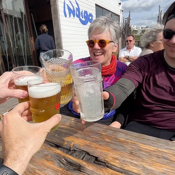 Cyclists sharing a celebratory drink at a sunny café stop