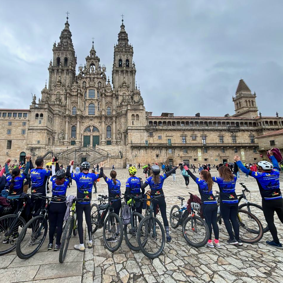 Cycling group celebrating their arrival at Santiago Cathedral