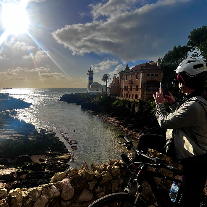 Cyclist overlooking a sunlit coastal bay at the end of the ride